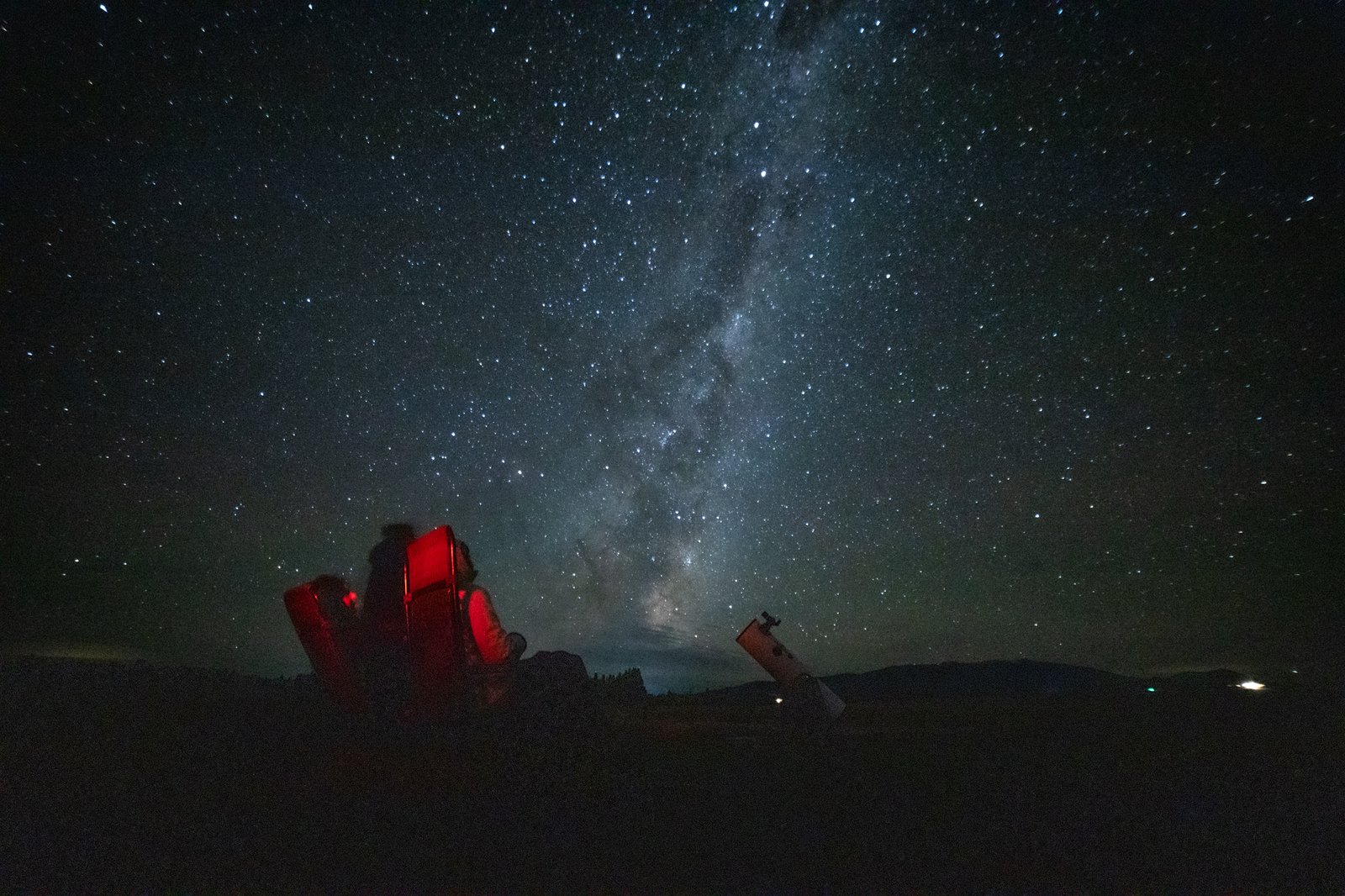 Guests stargazing from recliner chairs at High Country Cabin under the Milky Way